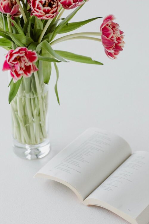Opened Paperback Book with Flowers in a Vase